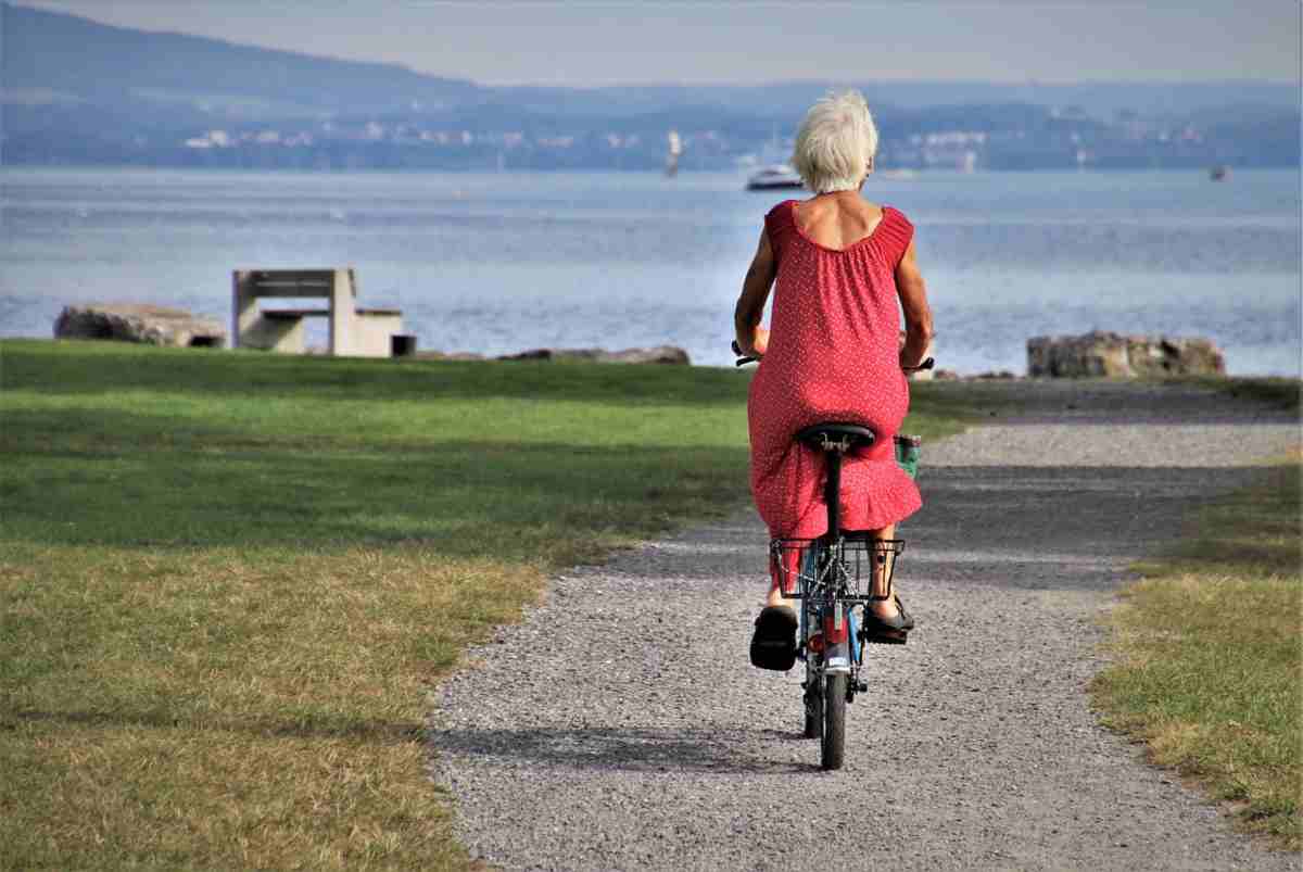 Signora anziana in bicicletta al parco