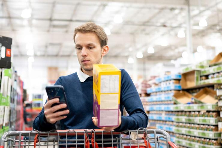 Ragazzo controlla lo smartphone al supermercato 