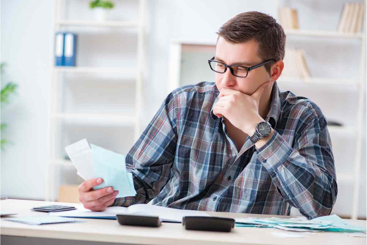 persona che guarda foglio e pensa