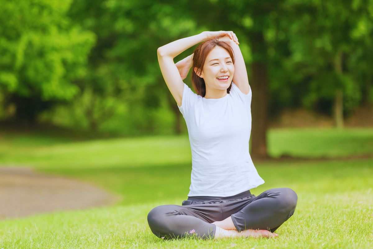 Giovane donna che pratica yoga su un prato