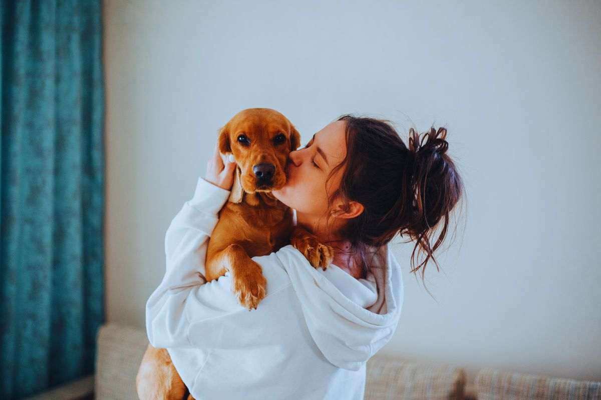 Ragazza che bacia il suo cane