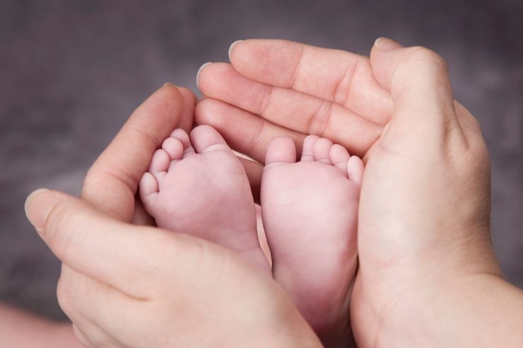 Mani mamma con piedini neonato