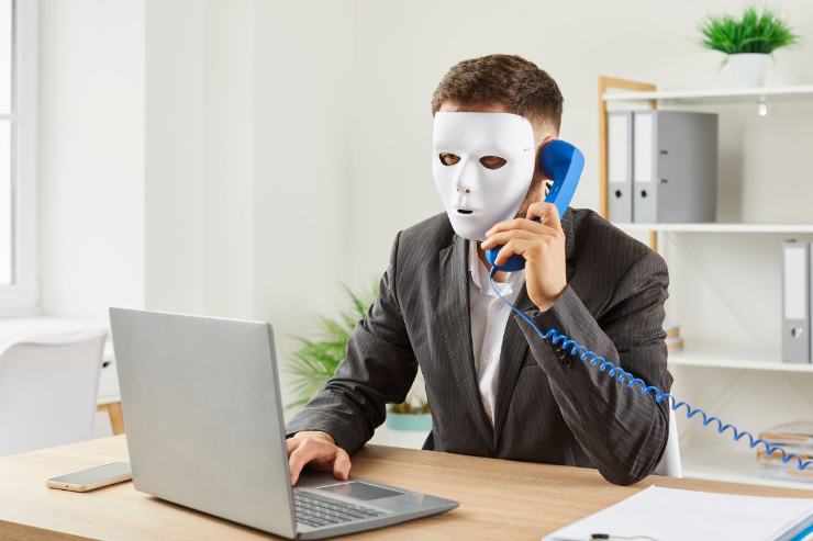 truffatore con maschera al telefono