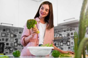 donna in cucina con broccoli