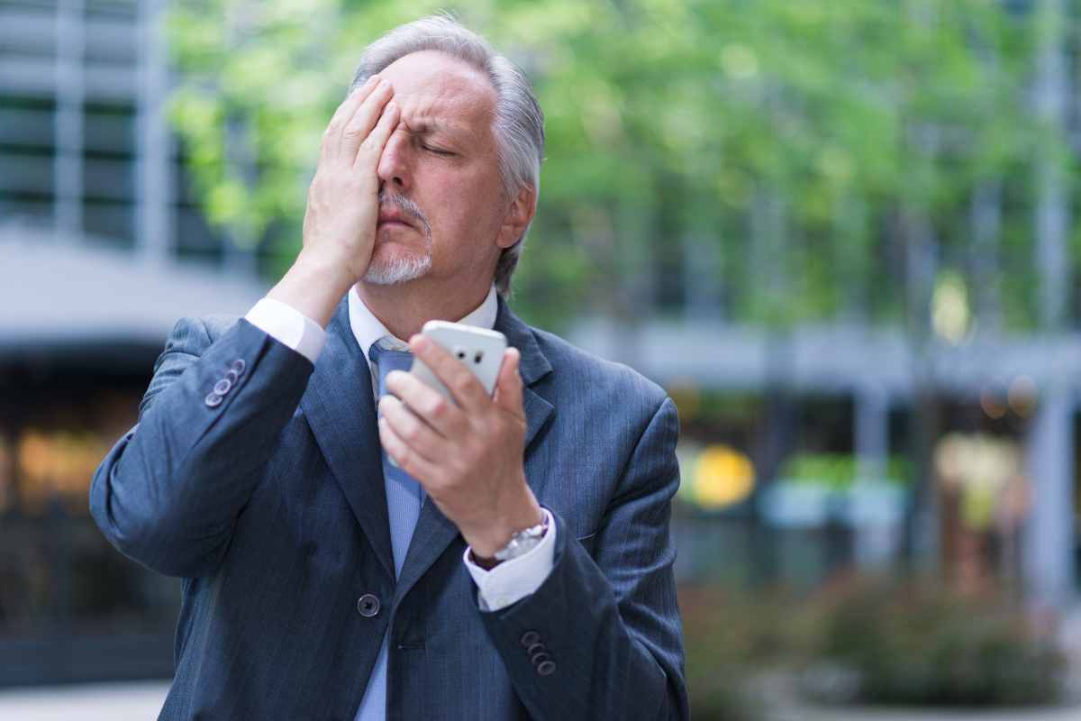 Uomo disperato mentre guarda il telefono