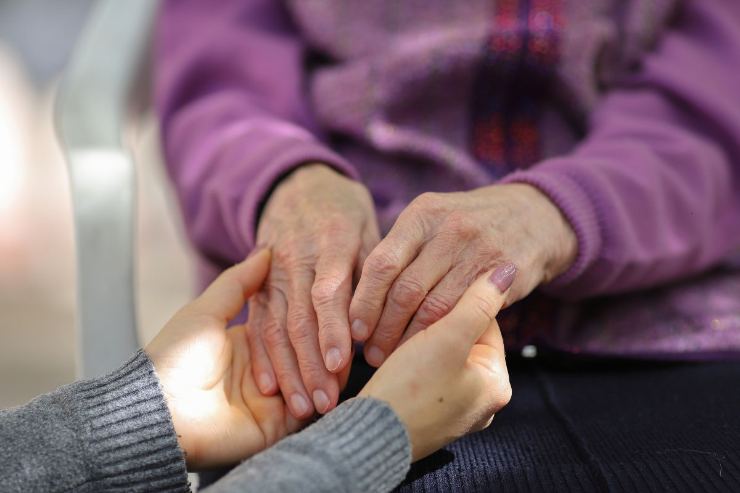 mani anziana dentro quelle di altra donna