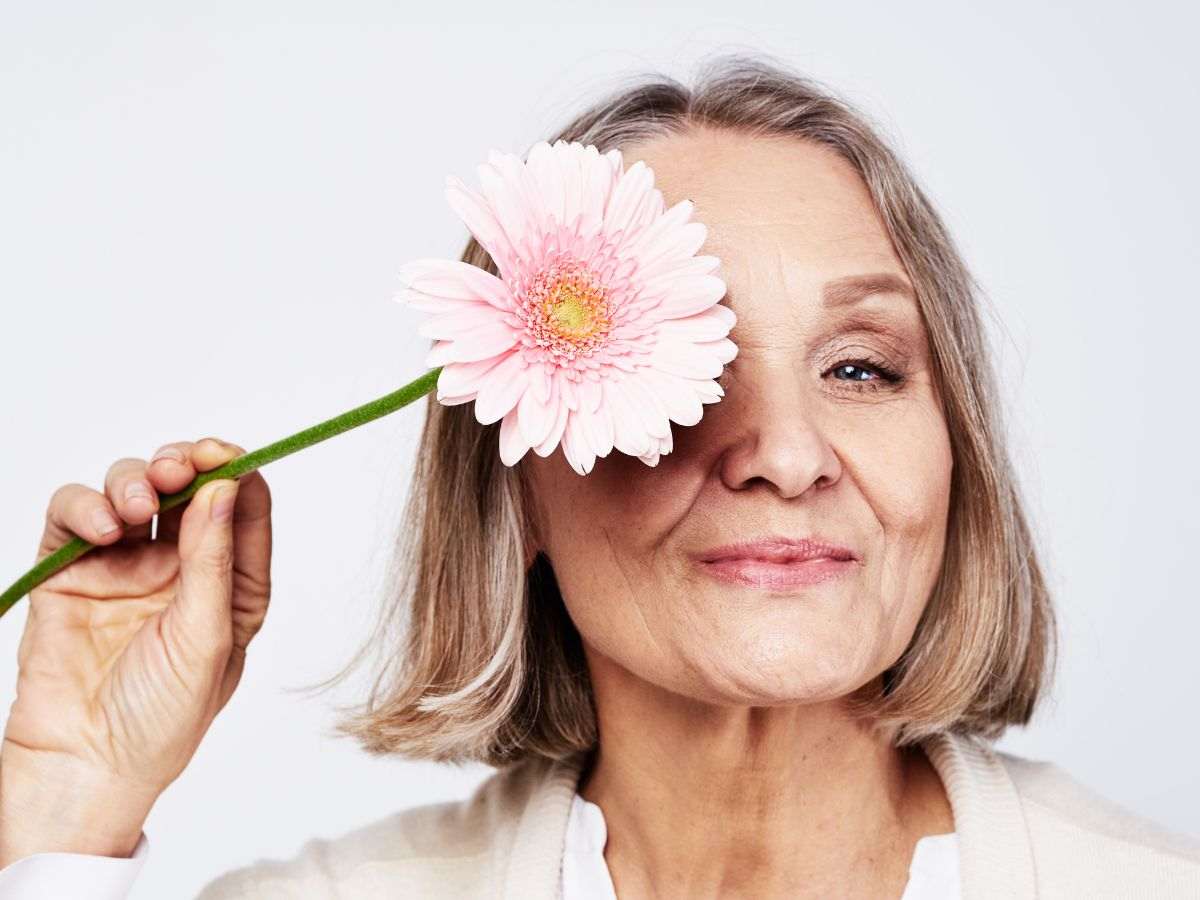 Donna con rughe e fiore rosa