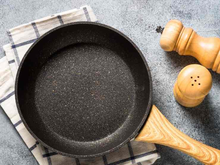 Padella con strofinaccio e sale e pepe vicino