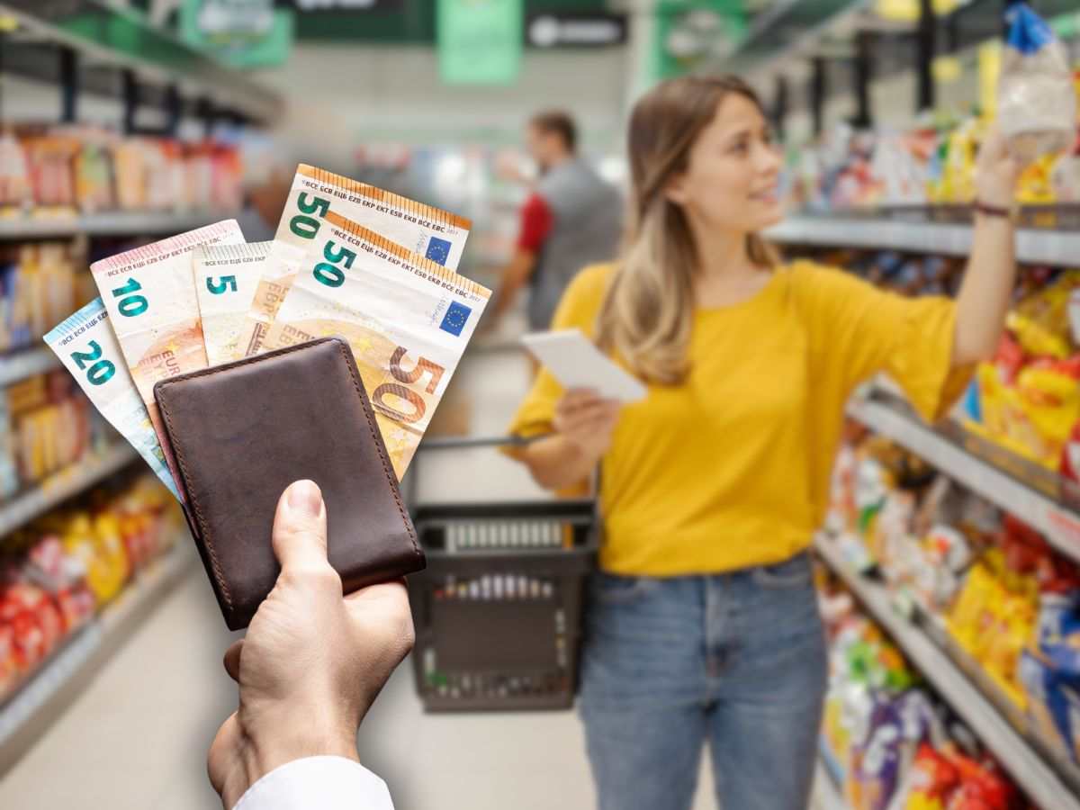 donna al supermercato e portafoglio con banconote da 50 euro