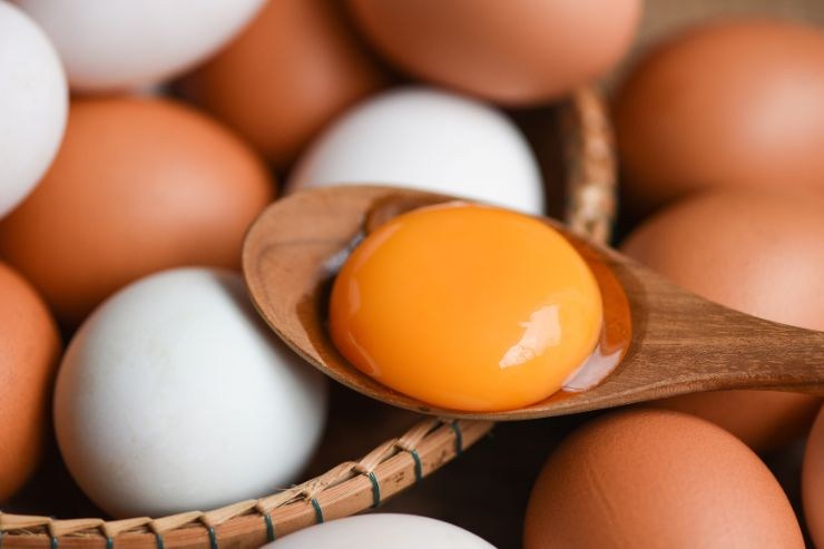 uova bianche e marroni con un rosso su cucchiaio